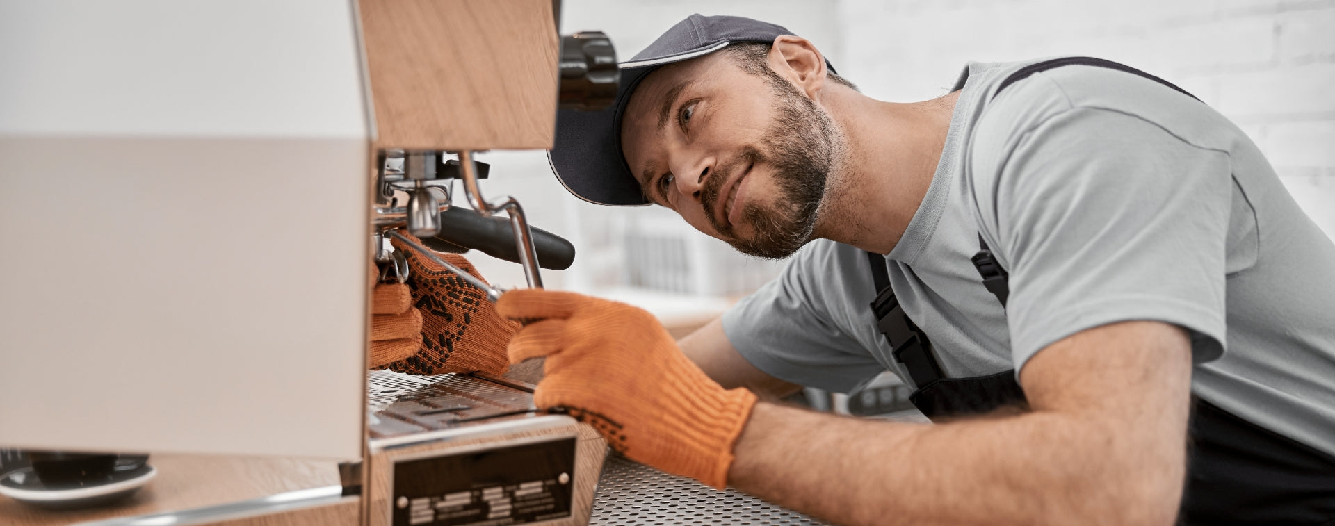 Eine Siebträger Kaffeemaschine wird von einem Mann repariert